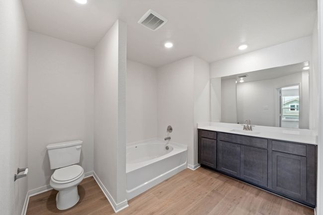Full bath with wood finished floors, a bath, toilet, vanity, and baseboards | Image 6