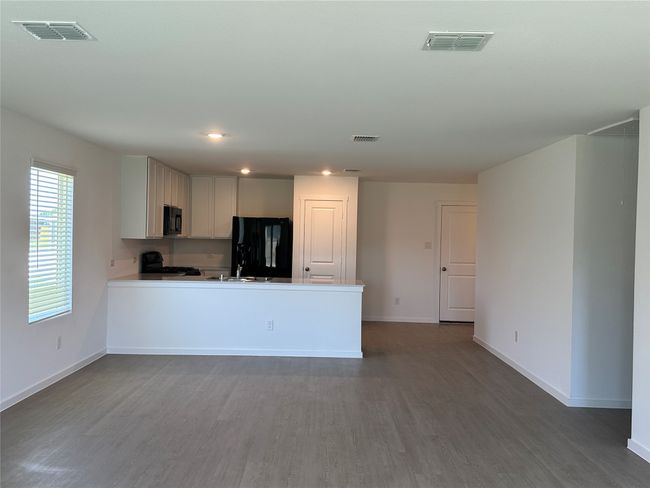 Kitchen with black appliances, wood finished floors, baseboards, and recessed lighting | Image 6