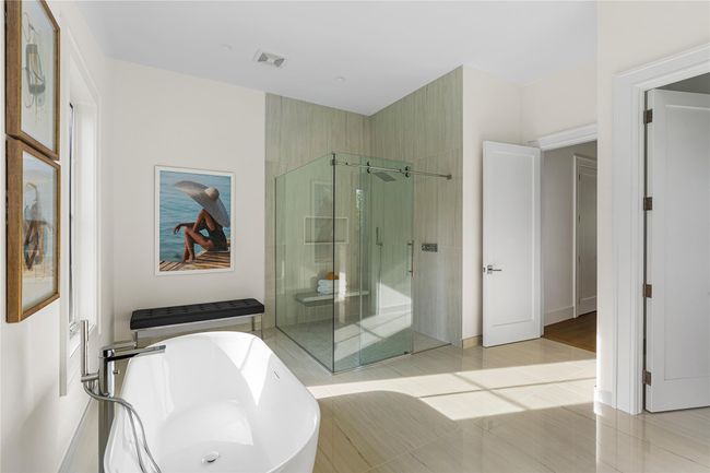 Full bath with a stall shower, a freestanding tub, and tile patterned floors | Image 27