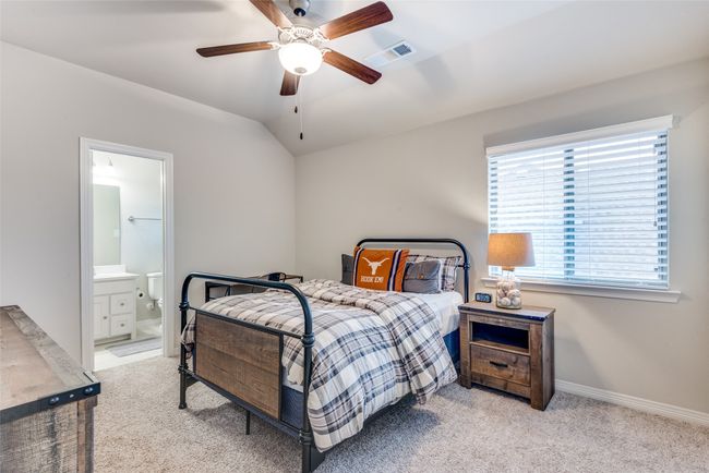 Bedroom with light carpet, baseboards, ensuite bathroom, vaulted ceiling, and ceiling fan | Image 12