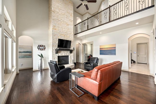 This look at the living room showcases the fireplace and second floor balcony. | Image 11