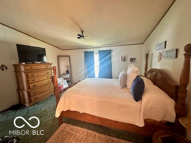 bedroom featuring lofted ceiling, carpet flooring, and a textured ceiling | Image 12