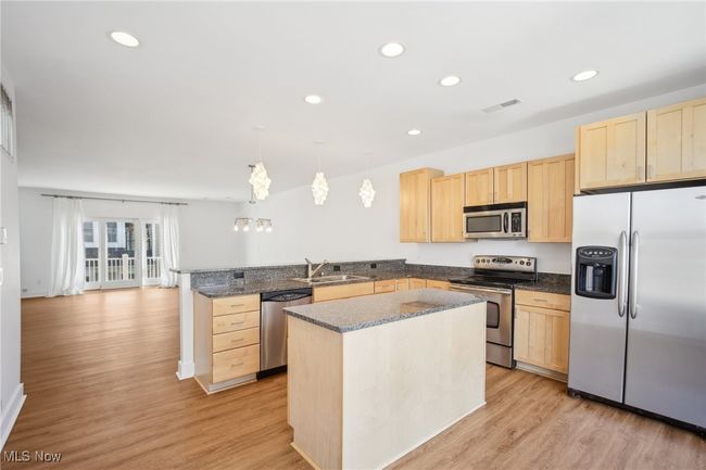 Kitchen featuring light brown cabinets, stainless steel appliances, a peninsula, and recessed lighting | Image 6