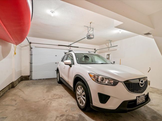 Garage featuring visible vents and a garage door opener | Image 31