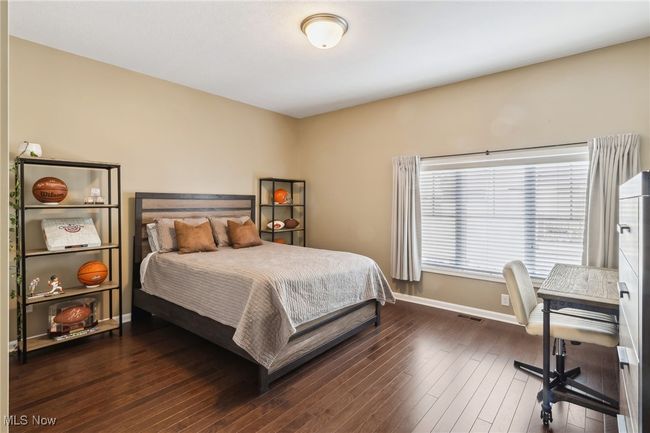 Open and inviting upstairs bedroom with wood floors | Image 29