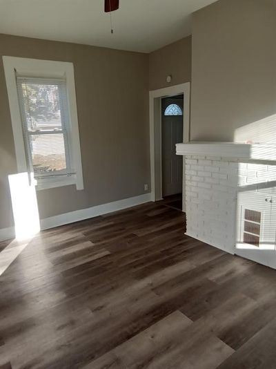 Unfurnished living room featuring dark wood-type flooring and ceiling fan | Image 2