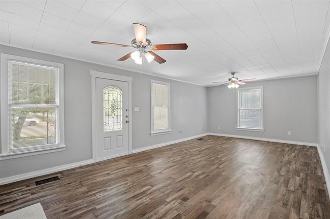 Entrance foyer with ceiling fan, dark wood-style floors, and crown molding | Image 6