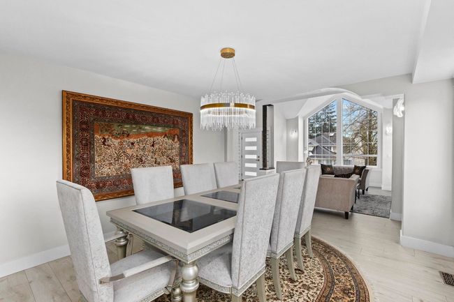 Dining area featuring a notable chandelier, light wood-type flooring, and baseboards | Image 6