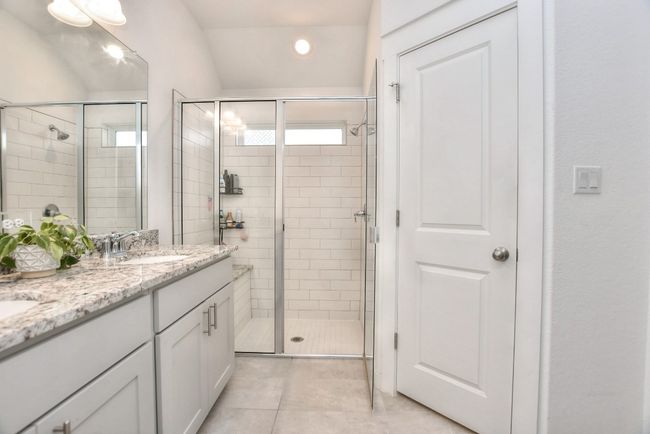 Full bathroom featuring a sink, tile patterned flooring, double vanity, and a stall shower | Image 23