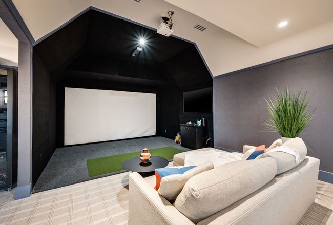 Carpeted cinema room with golf simulator, lofted ceiling, and recessed lighting | Image 25