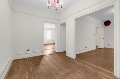 Hall that could be used as a seating area with wood-type flooring and a chandelier | Image 2