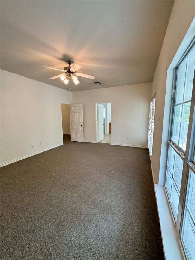 Carpeted empty room with a ceiling fan and baseboards | Image 13