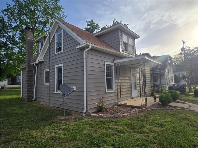 View of property exterior with a lawn and a chimney | Image 4