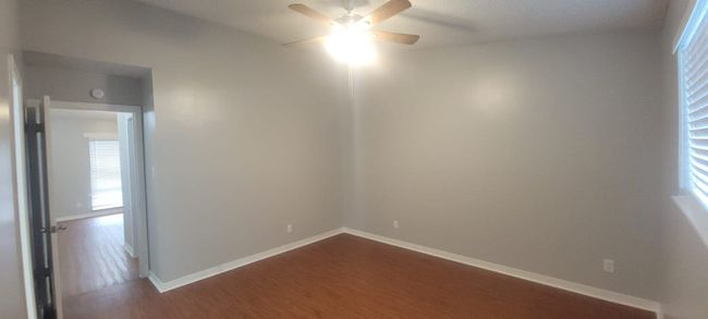 Unfurnished room featuring dark wood finished floors and a ceiling fan | Image 6