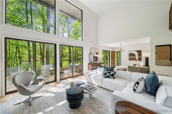 Living area with high vaulted ceiling, a notable chandelier, and wood finished floors | Image 15