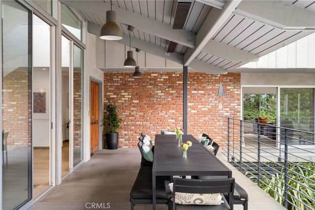 Overlooking the courtyard, a covered and heated deck that is perfect for entertaining features double entry doors that lead to the interior of the residence, where a heightened level of privacy, comfort and warmth embraces everyone who enters. | Image 20