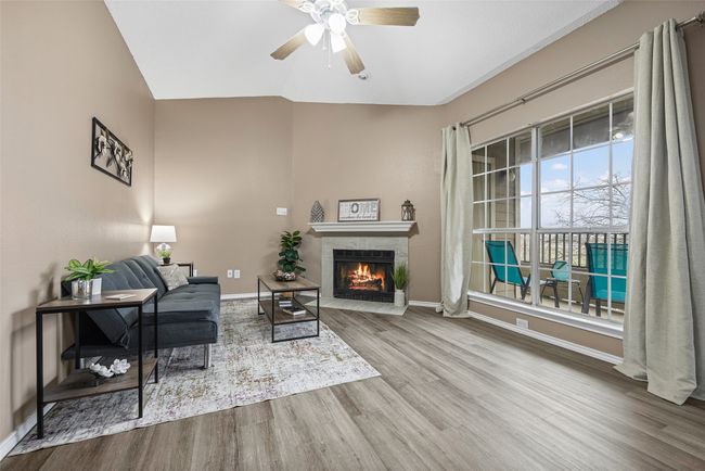 Sitting room featuring a tiled fireplace, hardwood / wood-style flooring, lofted ceiling, and ceiling fan | Image 7