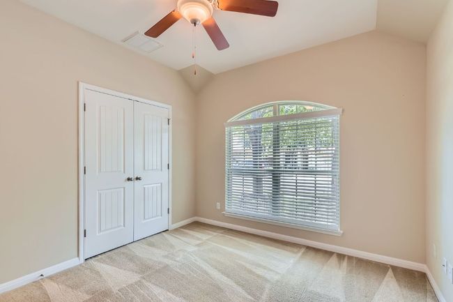 Bedroom two with light carpet, a closet, lofted ceiling, and a ceiling fan | Image 22