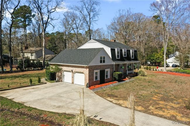 View of front facade with brick siding, a shingled roof, a front lawn, concrete driveway, and a garage | Image 42