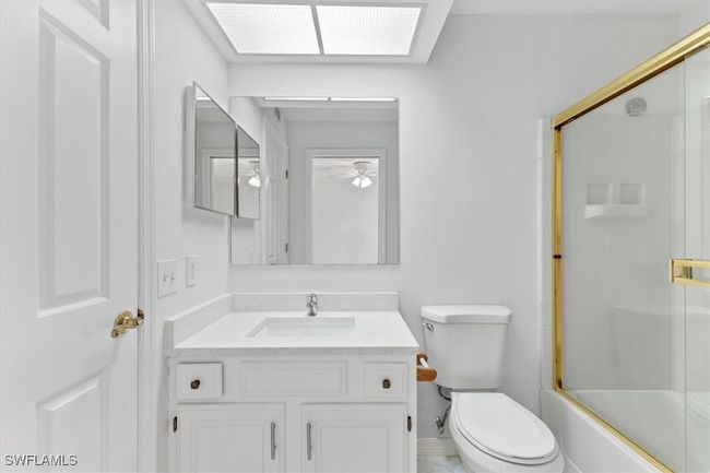 Full bathroom featuring vanity, toilet, tile patterned flooring, and bath / shower combo with glass door | Image 16