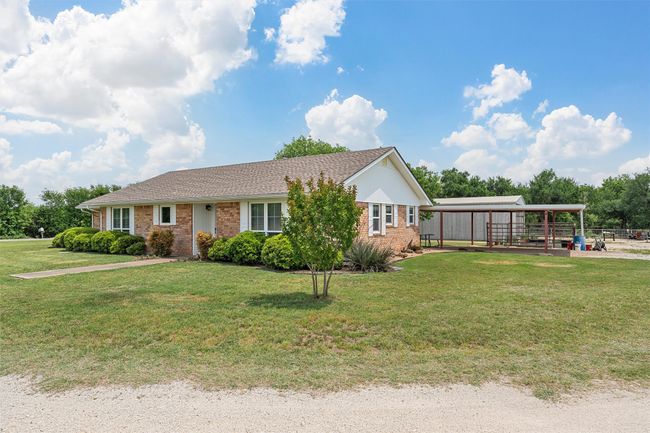 Ranch-style house featuring a detached carport, brick siding, and a front lawn | Image 29