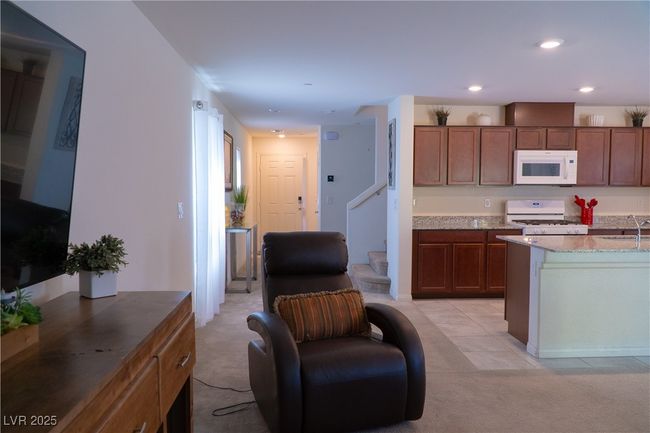 Kitchen featuring a sink, brown cabinets, white appliances, light colored carpet, and recessed lighting | Image 36
