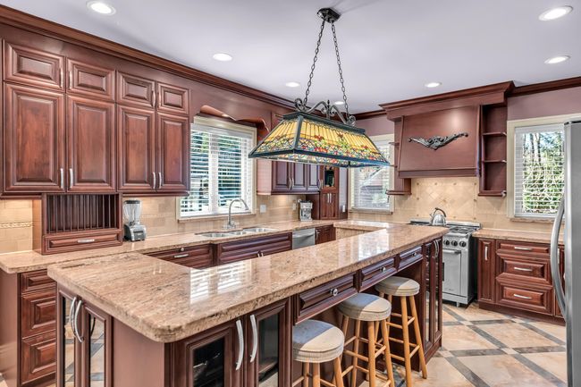 Kitchen with a sink, stainless steel appliances, wine cooler, recessed lighting, and a breakfast bar | Image 10