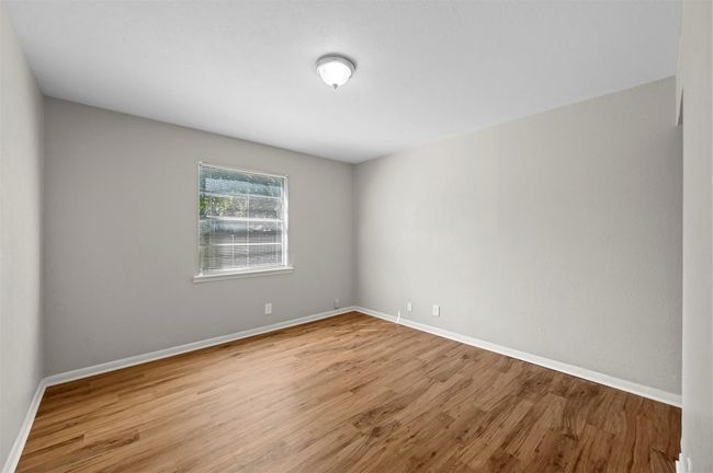 Spare room with wood finished floors and baseboards | Image 7