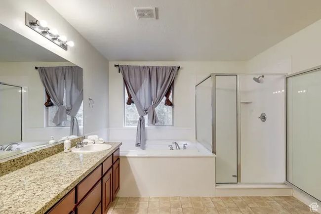 Bathroom featuring vanity, a stall shower, a garden tub, and visible vents | Image 23