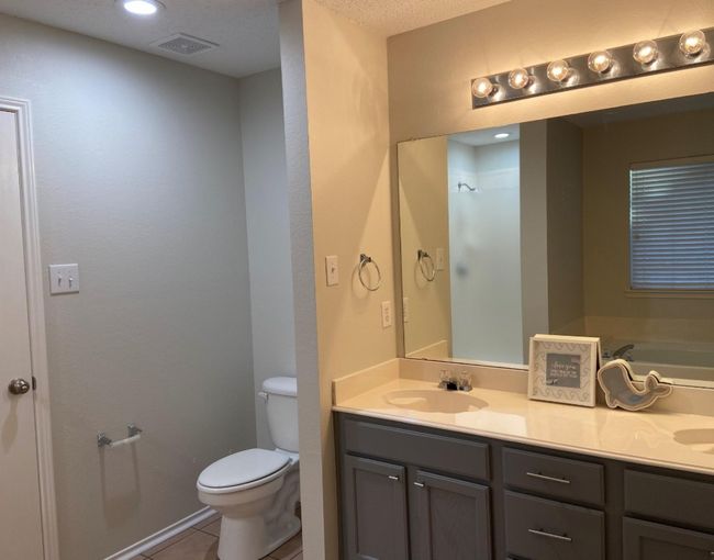 Full bathroom featuring light tile patterned floors, double vanity, a garden tub, recessed lighting, and a textured ceiling | Image 17