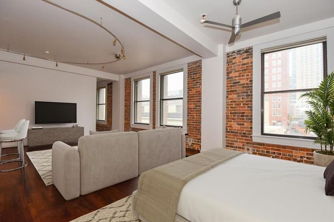 This spacious living room is filled with natural light from large windows that frame breathtaking views of downtown. A perfect space to relax or entertain with an unbeatable urban backdrop. | Image 6