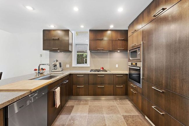 Kitchen featuring recessed lighting, a peninsula, modern cabinets, stainless steel appliances, and a large sized sink | Image 24
