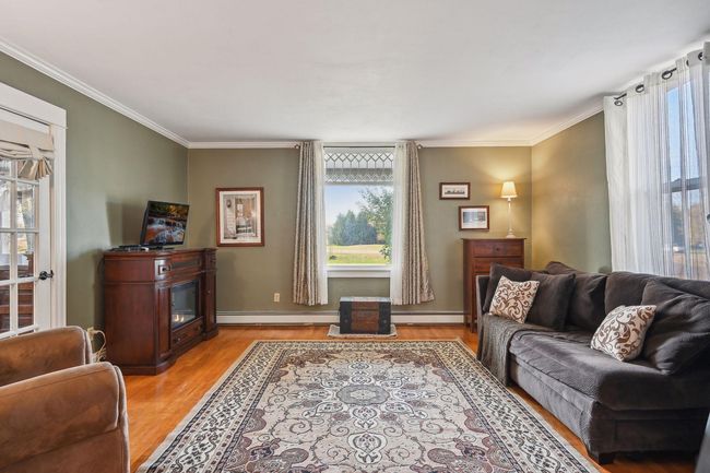 This is the livingroom at the front of the house. Notice the details in the window at the top. This room also has the original hardwood floors and has been recently painted. | Image 35