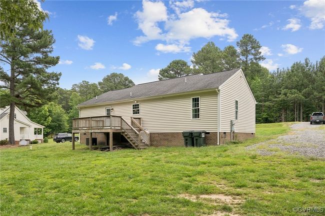 Back of house featuring a wooden deck, a yard, crawl space, stairway, and a shingled roof | Image 33
