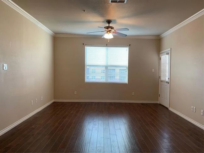 Unfurnished room with ceiling fan, ornamental molding, and dark wood finished floors | Image 21