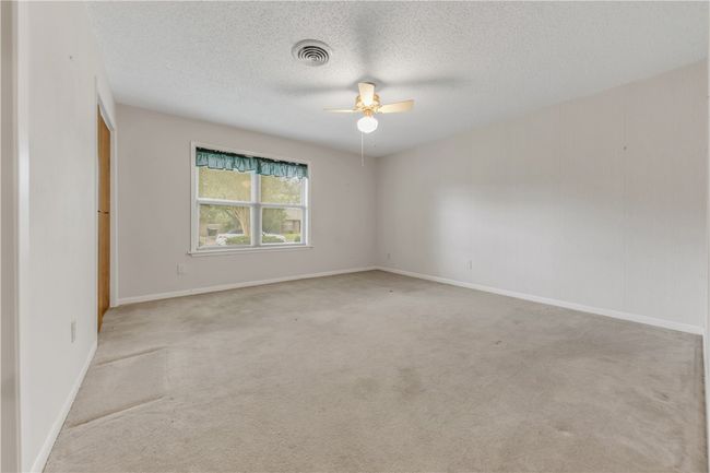 Unfurnished room featuring ceiling fan, light colored carpet, and a textured ceiling | Image 16
