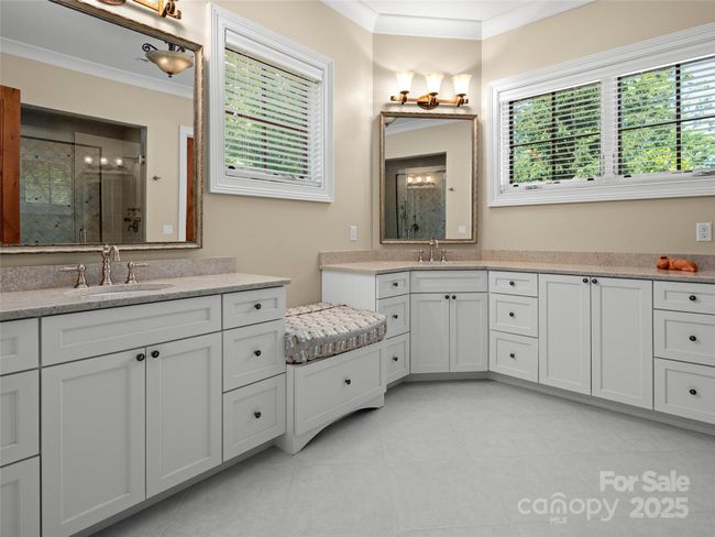 Primary bathroom has double granite vanities and windows that provide ample natural light. | Image 23