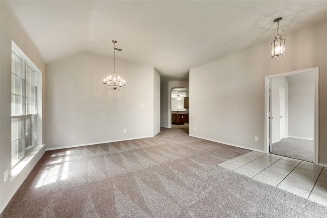Unfurnished dining area featuring a chandelier, carpet, arched walkways, and vaulted ceiling | Image 10