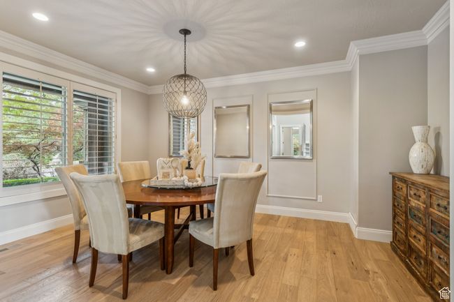Dining area featuring light wood finished floors, ornamental molding, and recessed lighting | Image 7