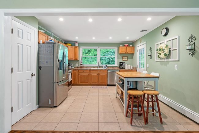 Kitchen with stainless steel appliances, a sink, light tile patterned floors, light countertops, and recessed lighting | Image 21