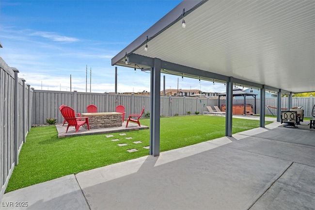 View of patio / terrace with a fenced backyard, a fire pit, and a hot tub | Image 30