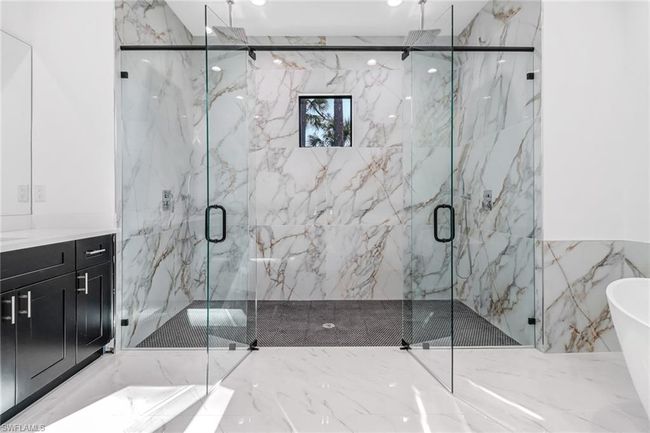 Bathroom featuring tile walls, independent shower and bath, tile patterned floors, and vanity | Image 26