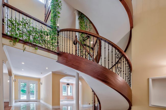 Stairway with french doors, baseboards, crown molding, and a high ceiling | Image 4