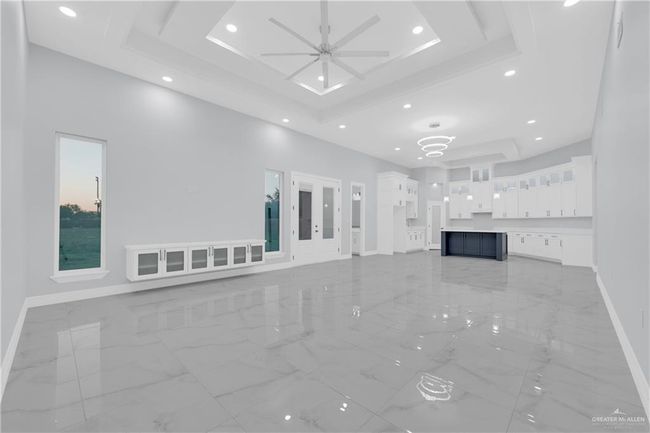 Unfurnished living room featuring baseboards, a raised ceiling, marble finish floor, and recessed lighting | Image 14