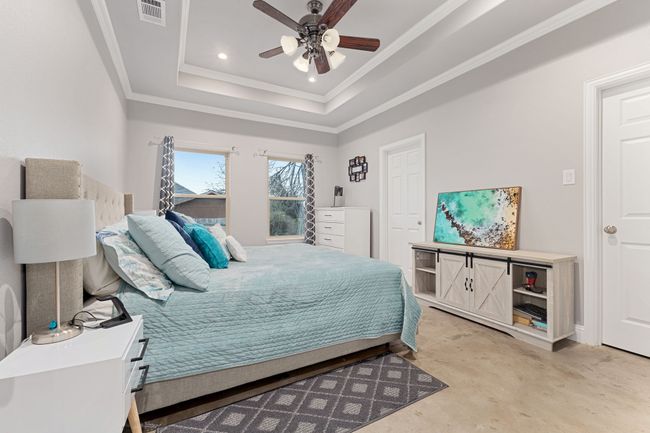 Bedroom with ceiling fan, ornamental molding, and a tray ceiling | Image 15