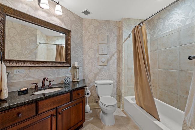 Full bathroom featuring vanity, wallpapered walls, shower / bath combo with shower curtain, and tile patterned floors | Image 27