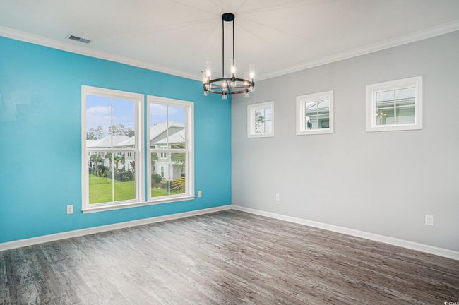 Unfurnished room featuring a chandelier, wood finished floors, and ornamental molding | Image 11