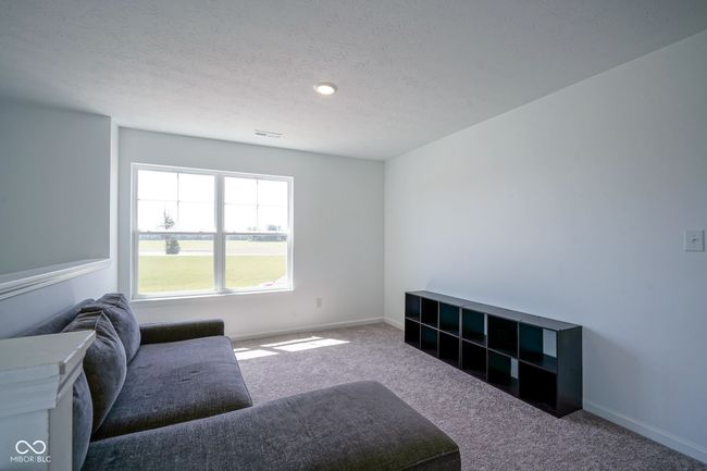 carpeted living room featuring baseboards and a textured ceiling | Image 19