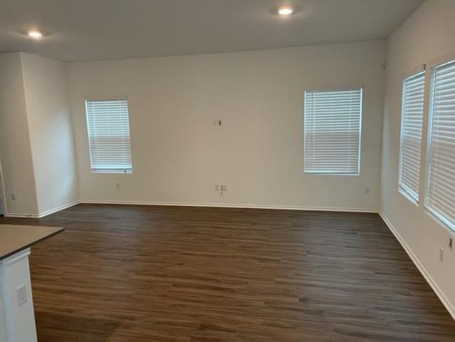 Empty room with dark wood-type flooring, recessed lighting, and baseboards | Image 16