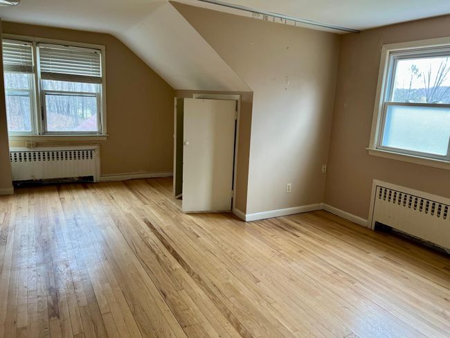Additional living space featuring light wood-style flooring, radiator, and baseboards | Image 16